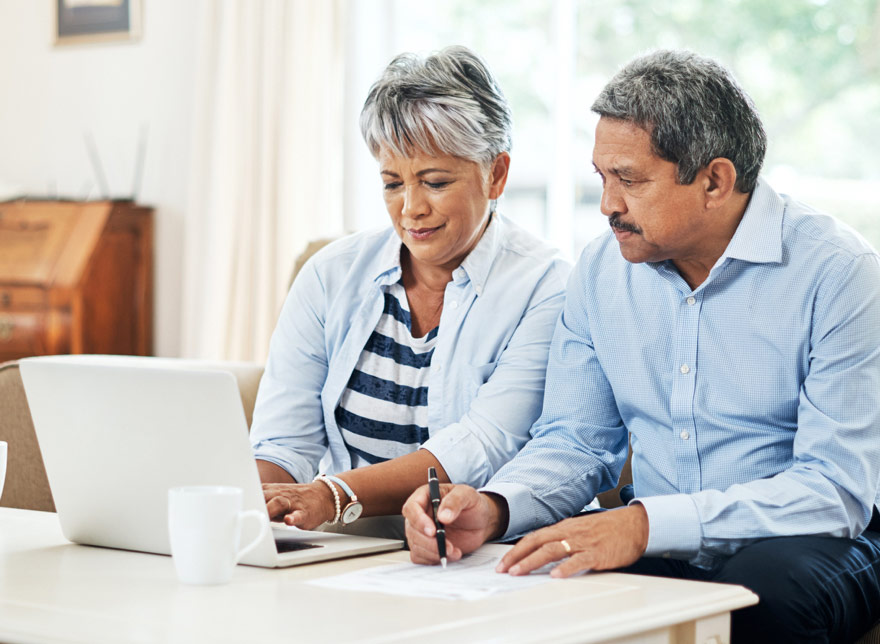 Husband and wife looking at their Crawfield Credit Union account on the computer together.